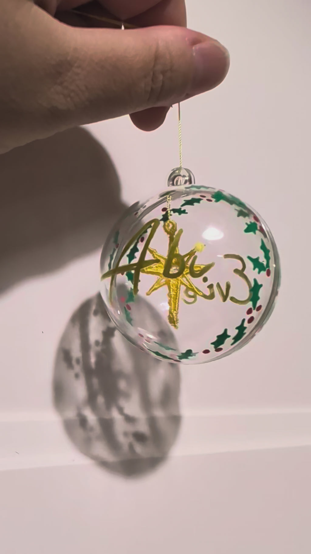 Personalised hand painted name bauble with embroidered star suspended in centre