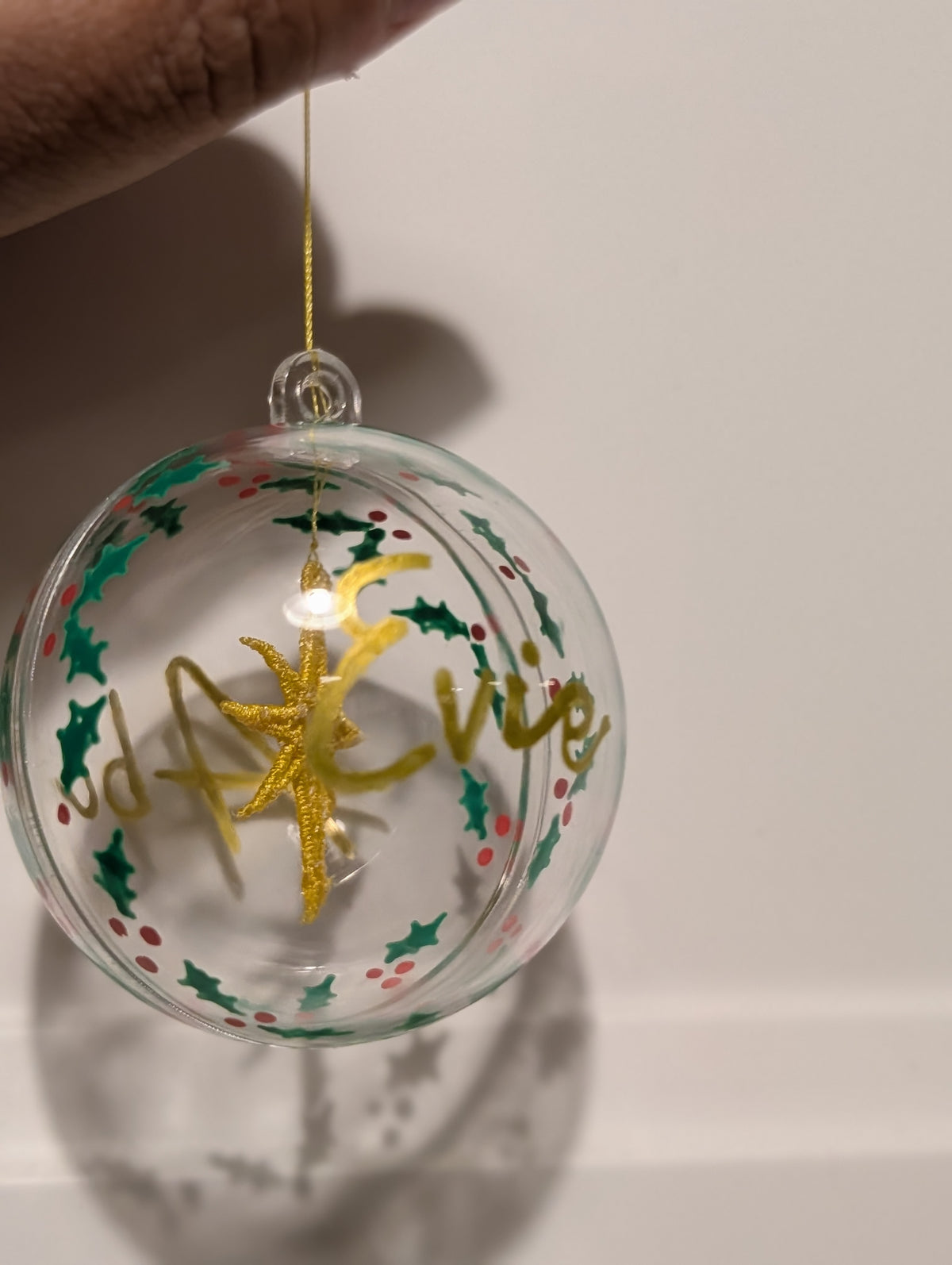Personalised hand painted name bauble with embroidered star suspended in centre
