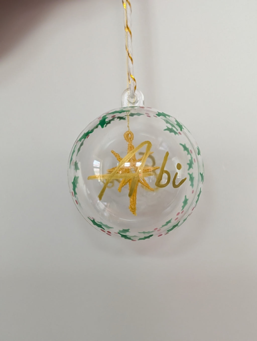 Personalised hand painted name bauble with embroidered star suspended in centre