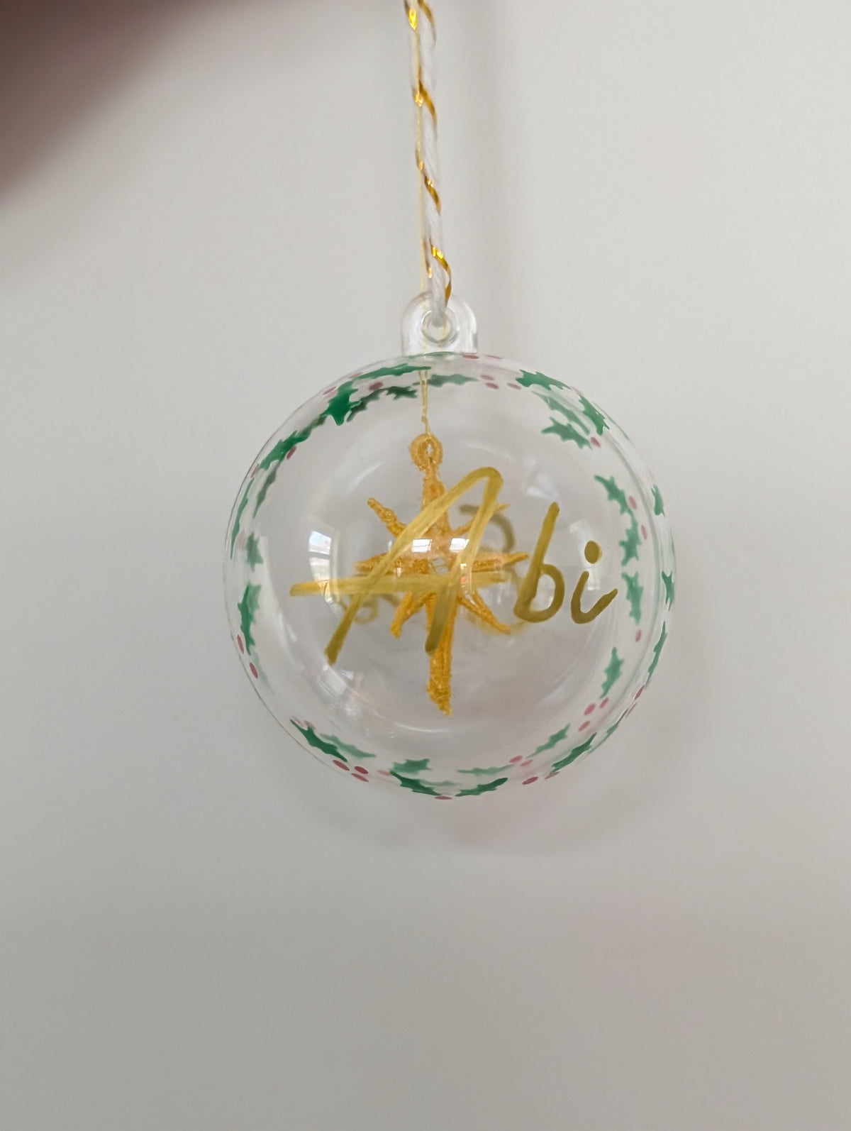 Personalised hand painted name bauble with embroidered star suspended in centre