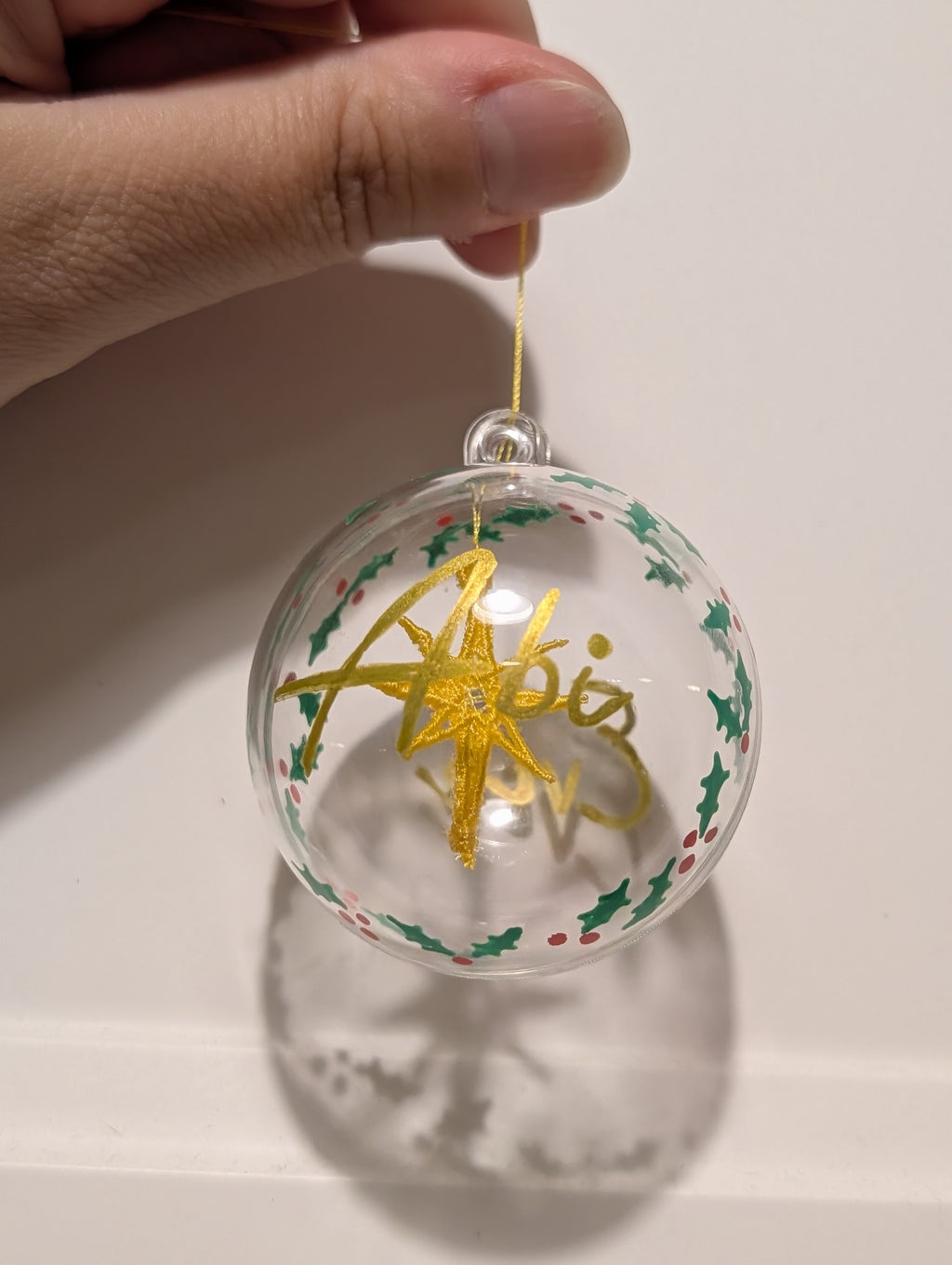 Personalised hand painted name bauble with embroidered star suspended in centre