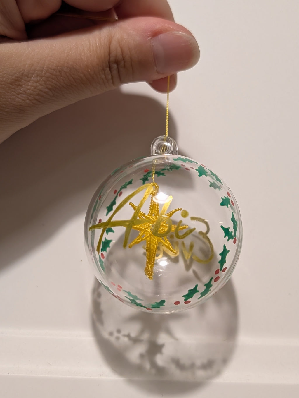 Personalised hand painted name bauble with embroidered star suspended in centre