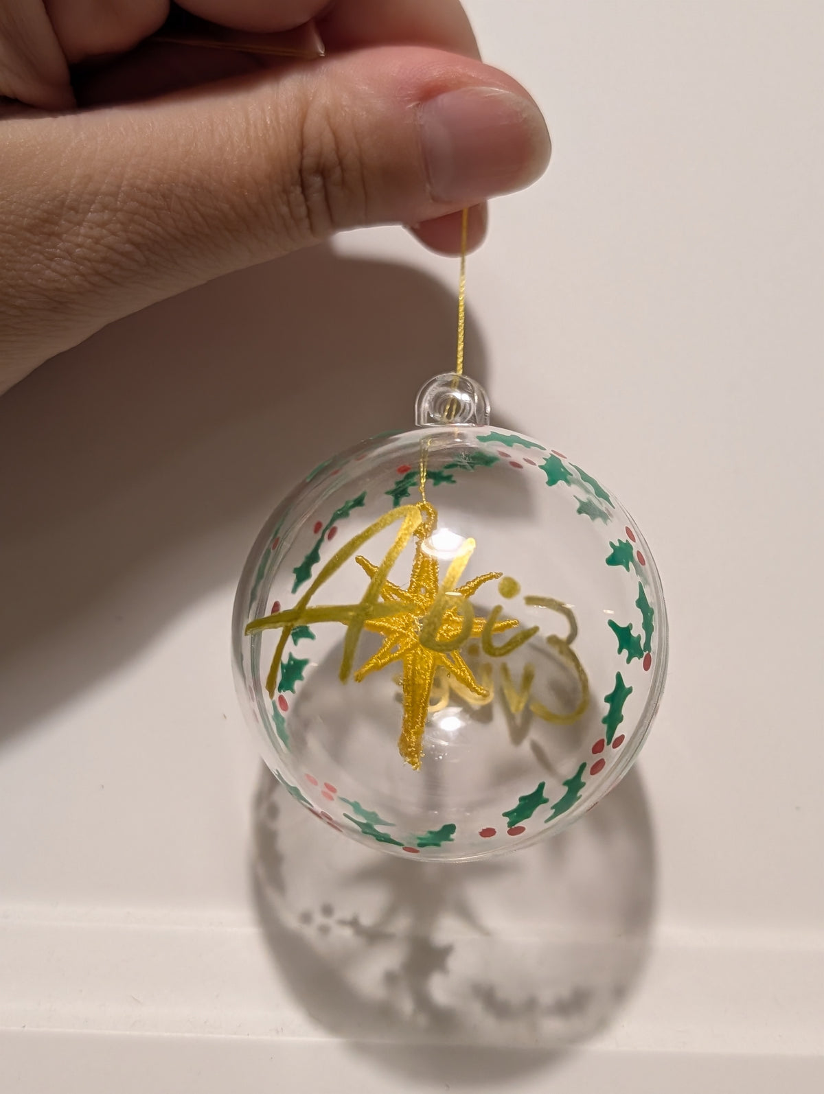 Personalised hand painted name bauble with embroidered star suspended in centre