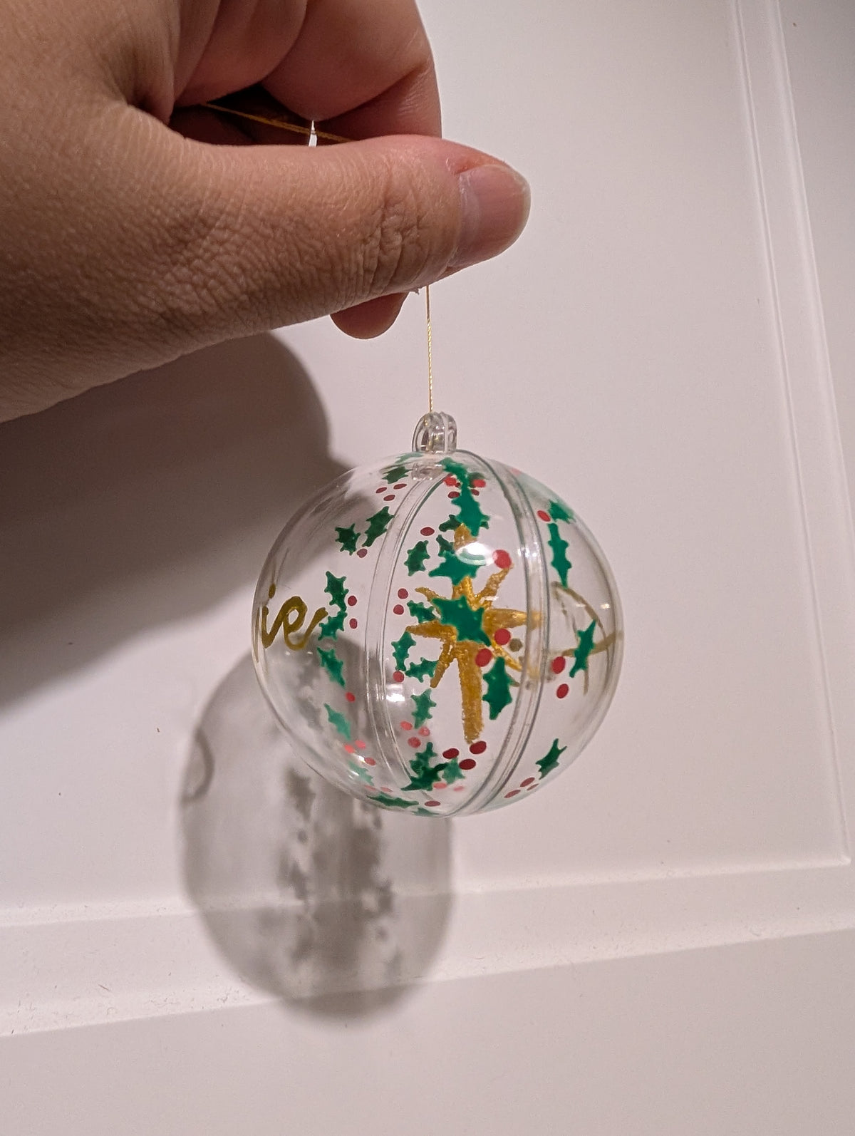 Personalised hand painted name bauble with embroidered star suspended in centre