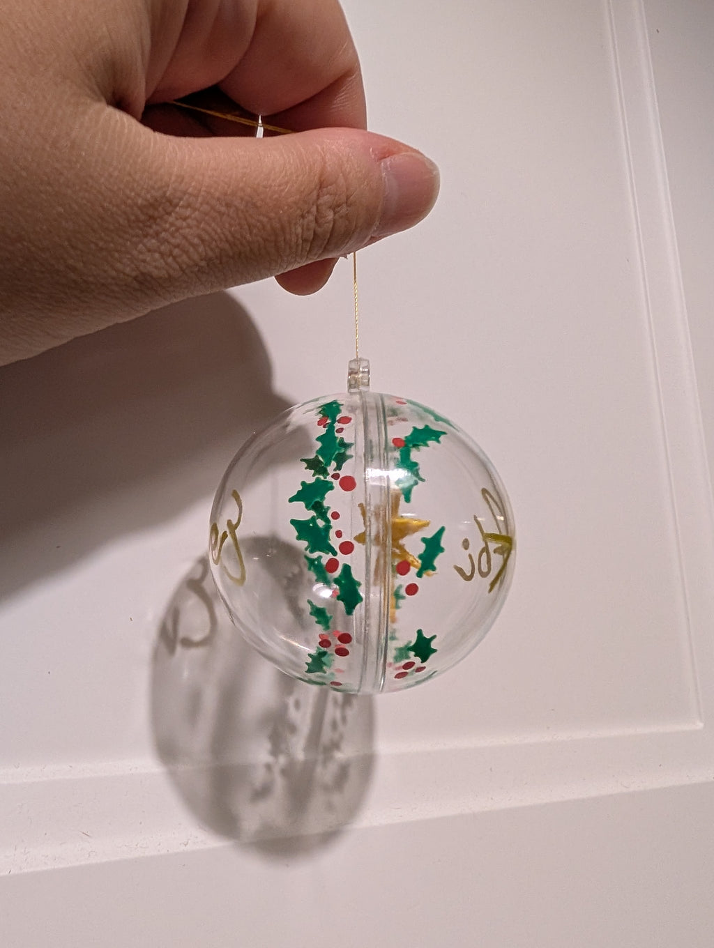 Personalised hand painted name bauble with embroidered star suspended in centre