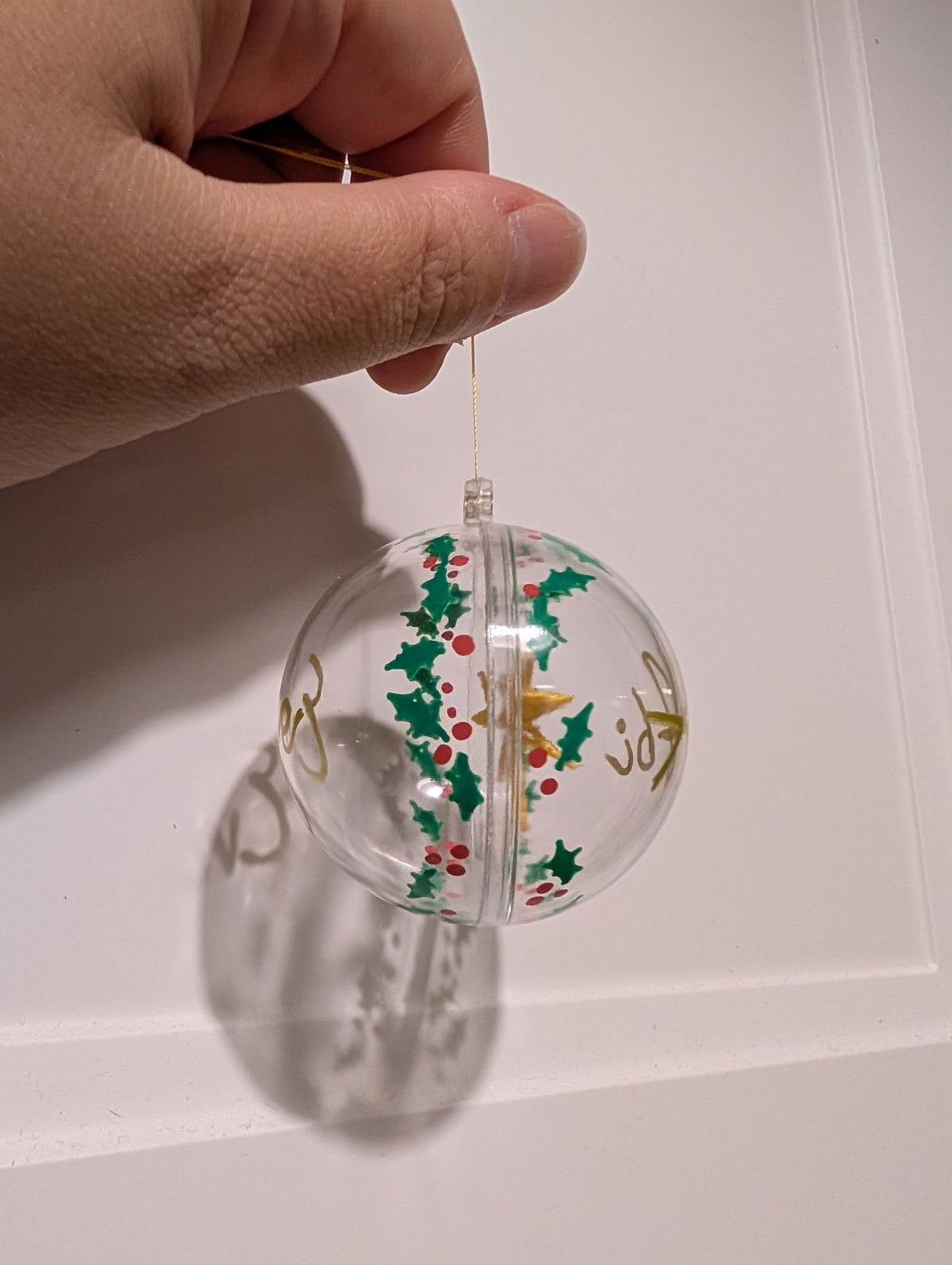 Personalised hand painted name bauble with embroidered star suspended in centre