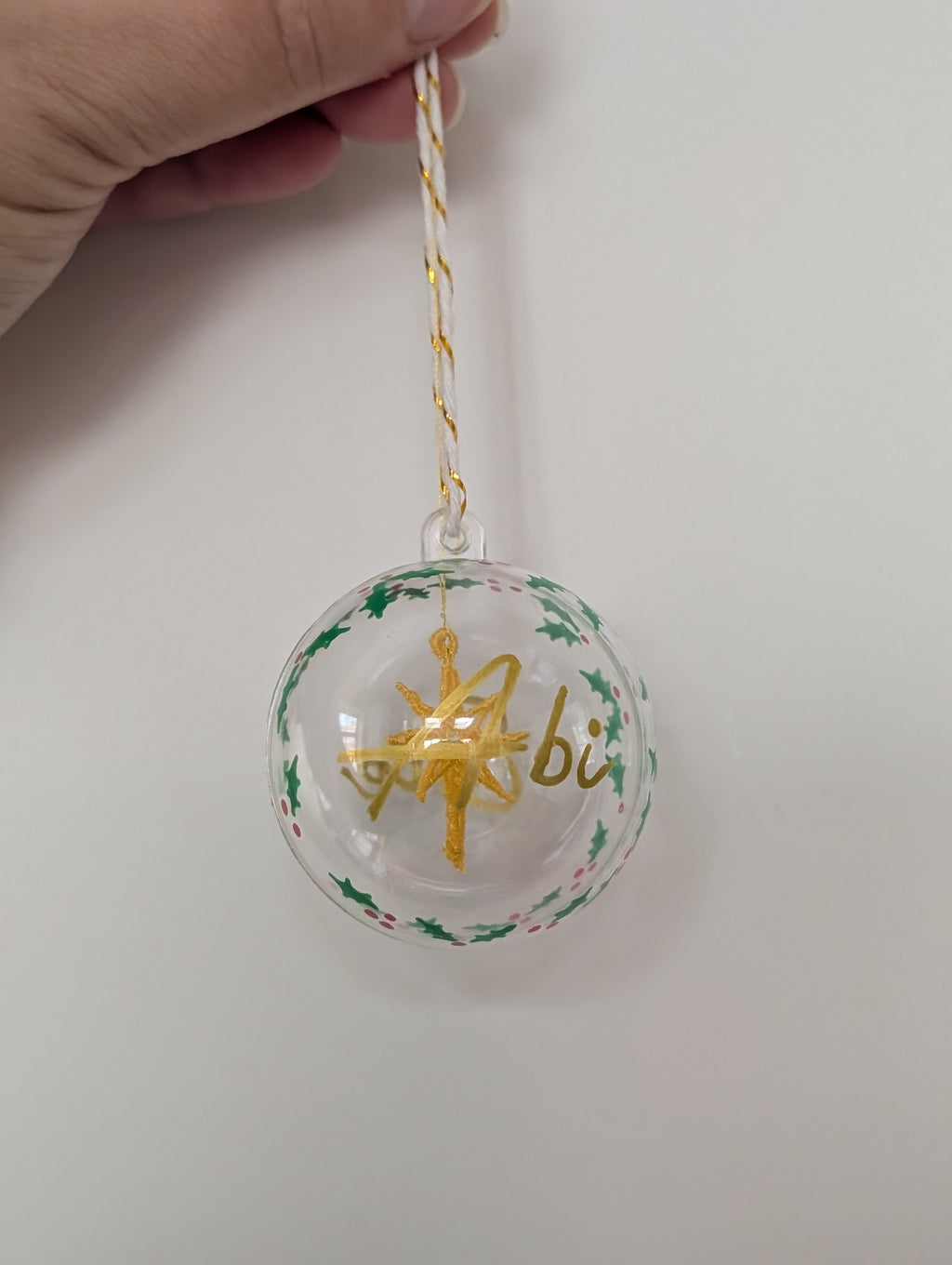 Personalised hand painted name bauble with embroidered star suspended in centre