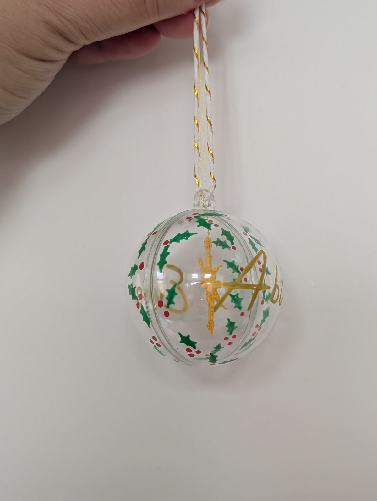 Personalised hand painted name bauble with embroidered star suspended in centre