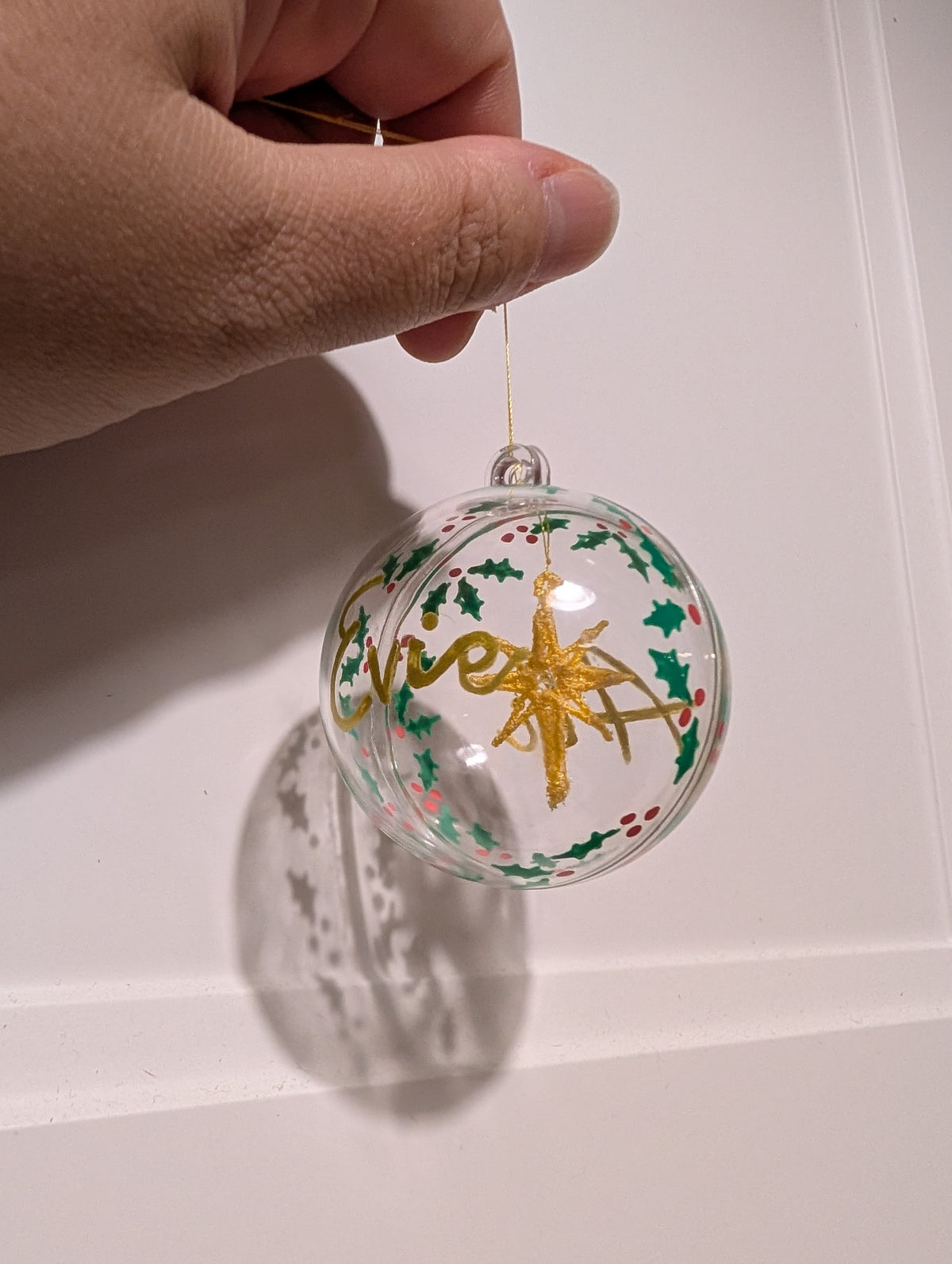 Personalised hand painted name bauble with embroidered star suspended in centre