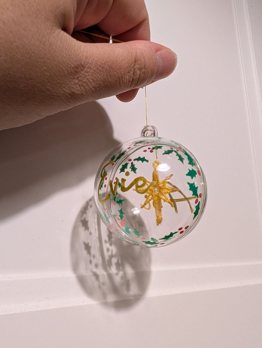 Personalised hand painted name bauble with embroidered star suspended in centre