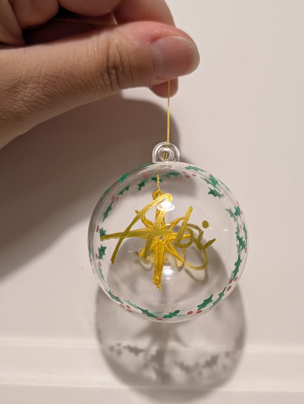 Personalised hand painted name bauble with embroidered star suspended in centre